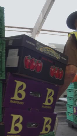 Vertical-Video-Of-Loading-Bay-Of-UK-Food-Bank-Building-With-Food-Being-Loaded-Into-Vans-